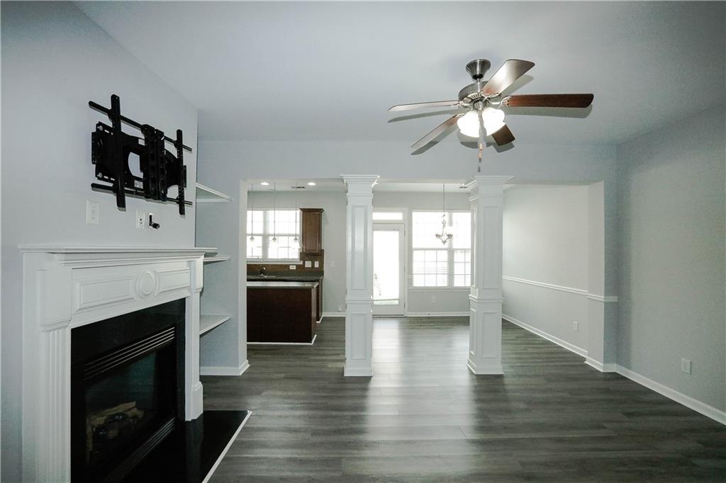2410 Sardis Chase Court Buford, GA 30519 - Photo 5 of 35 a view of a kitchen with a stove a fireplace a ceiling fan and wooden floor