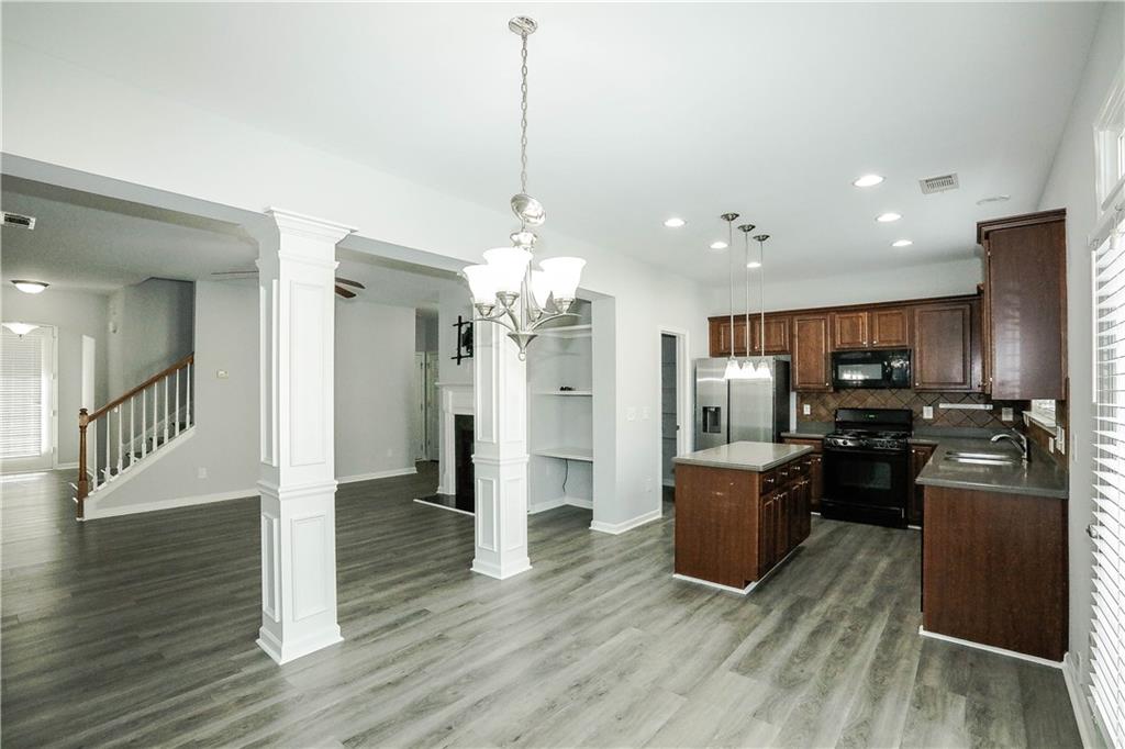 2410 Sardis Chase Court Buford, GA 30519 - Photo 7 of 35 a kitchen with stainless steel appliances kitchen island granite countertop a refrigerator and a wooden floor