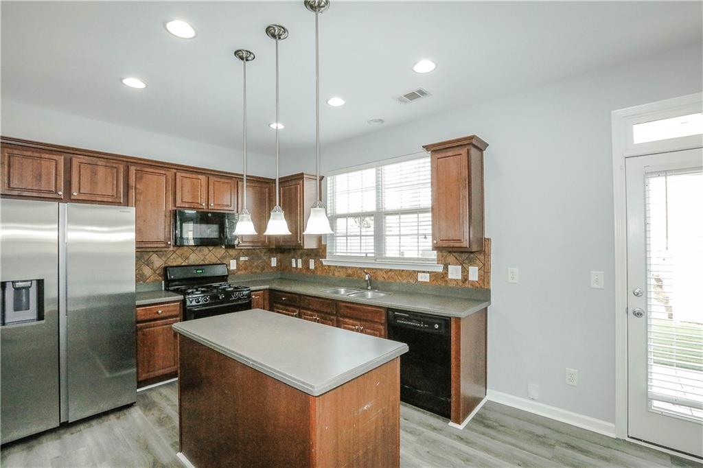 2410 Sardis Chase Court Buford, GA 30519 - Photo 9 of 35 a kitchen with stainless steel appliances granite countertop a sink a stove a refrigerator cabinets and a window
