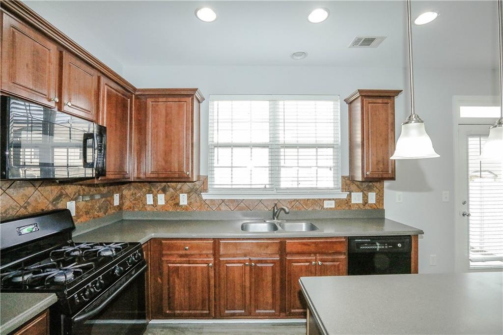 2410 Sardis Chase Court Buford, GA 30519 - Photo 10 of 35 a kitchen with stainless steel appliances granite countertop a stove a sink and a microwave