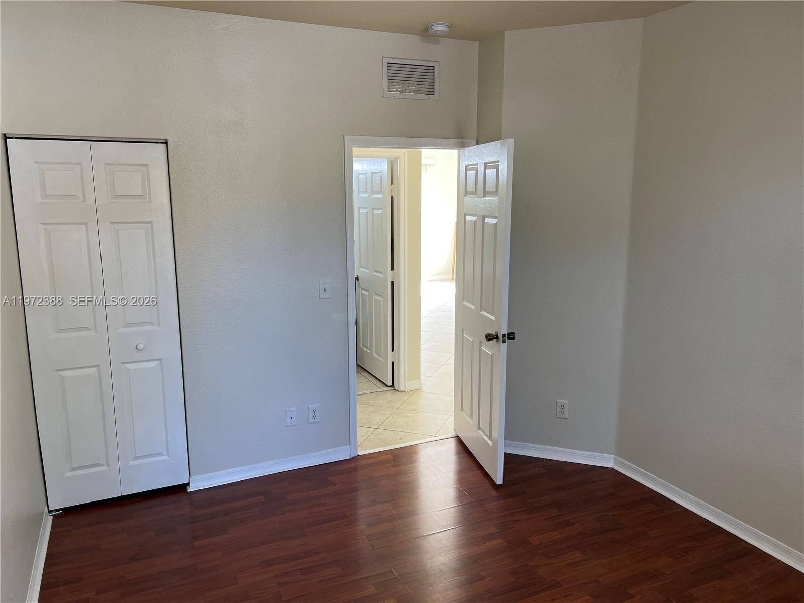 100 Southwest 15th Avenue Homestead, FL 33030 - Photo 17 of 62 an empty room with wooden floor and closet