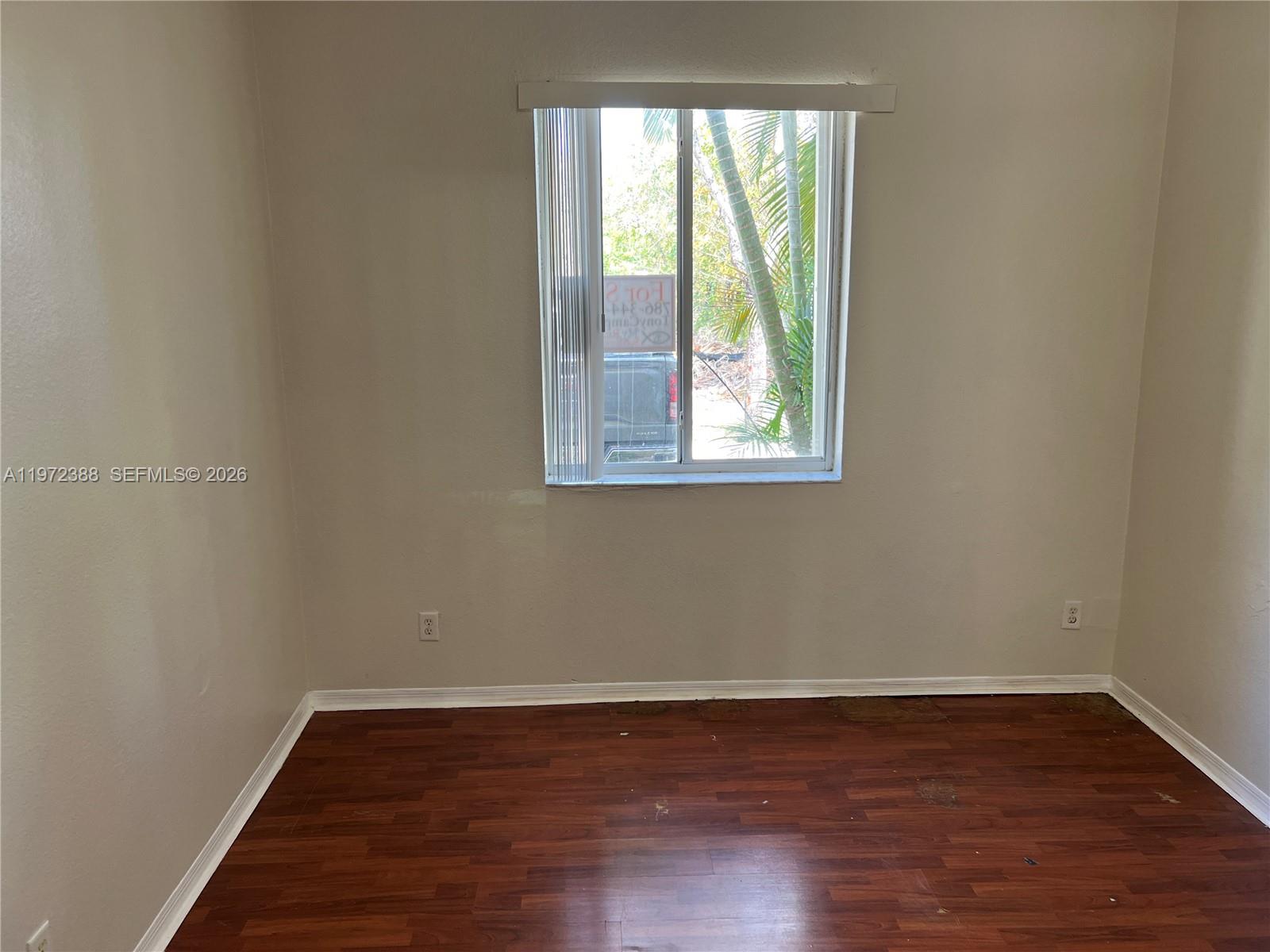 100 Southwest 15th Avenue Homestead, FL 33030 - Photo 18 of 62 a view of an empty room with wooden floor and a window