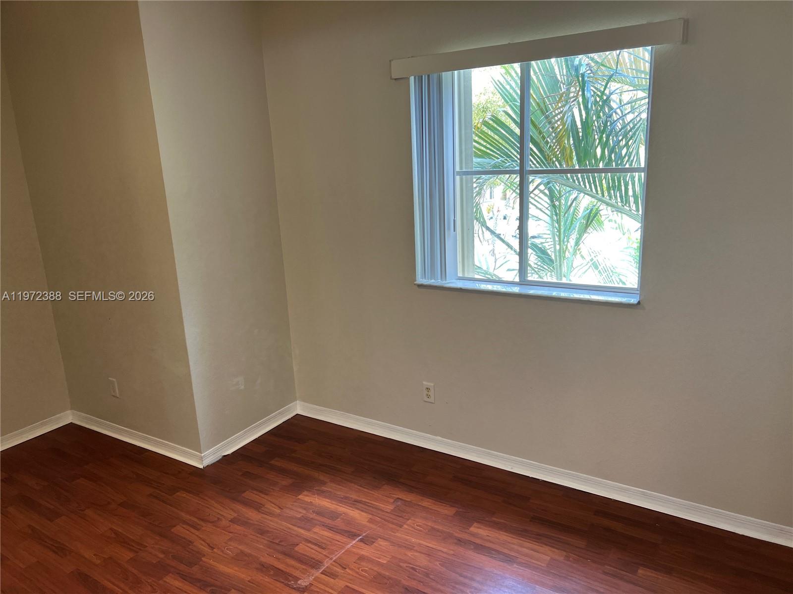 100 Southwest 15th Avenue Homestead, FL 33030 - Photo 30 of 62 an empty room with wooden floor and windows