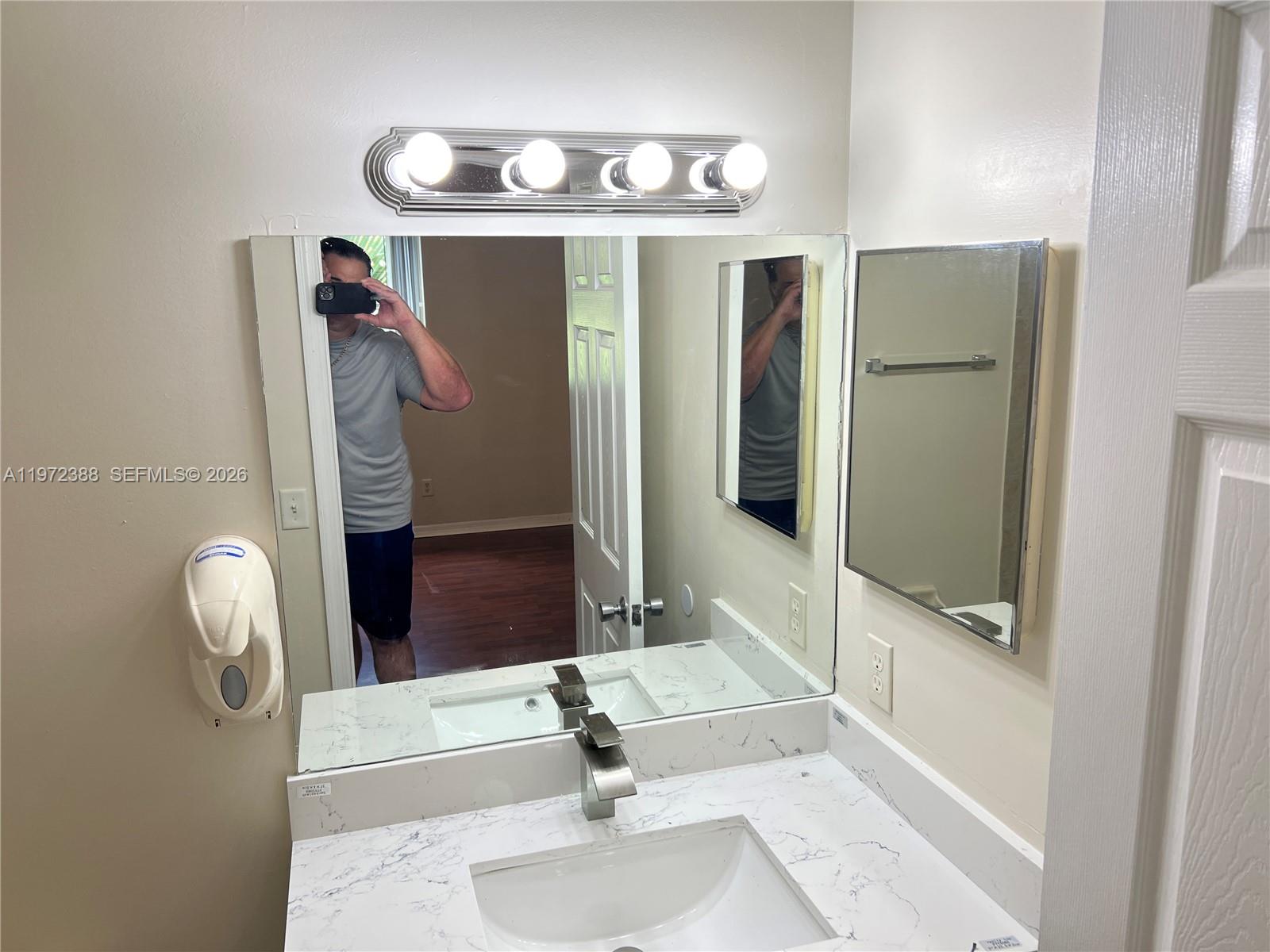 100 Southwest 15th Avenue Homestead, FL 33030 - Photo 36 of 62 a bathroom with a sink a mirror and shower