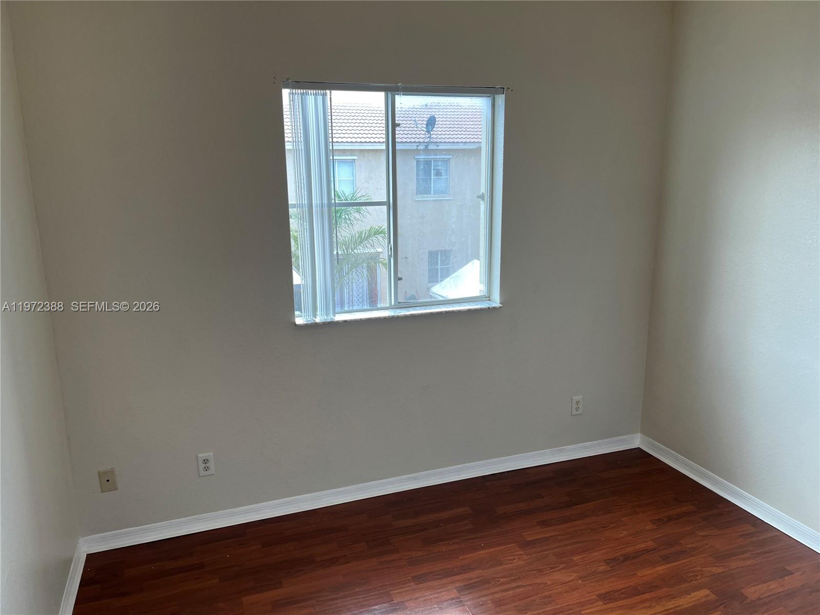 100 Southwest 15th Avenue Homestead, FL 33030 - Photo 45 of 62 a view of an empty room with wooden floor and a window