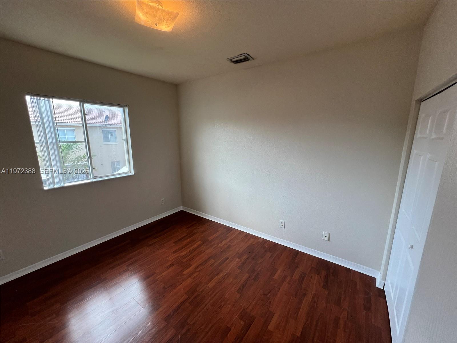 100 Southwest 15th Avenue Homestead, FL 33030 - Photo 46 of 62 an empty room with wooden floor and windows