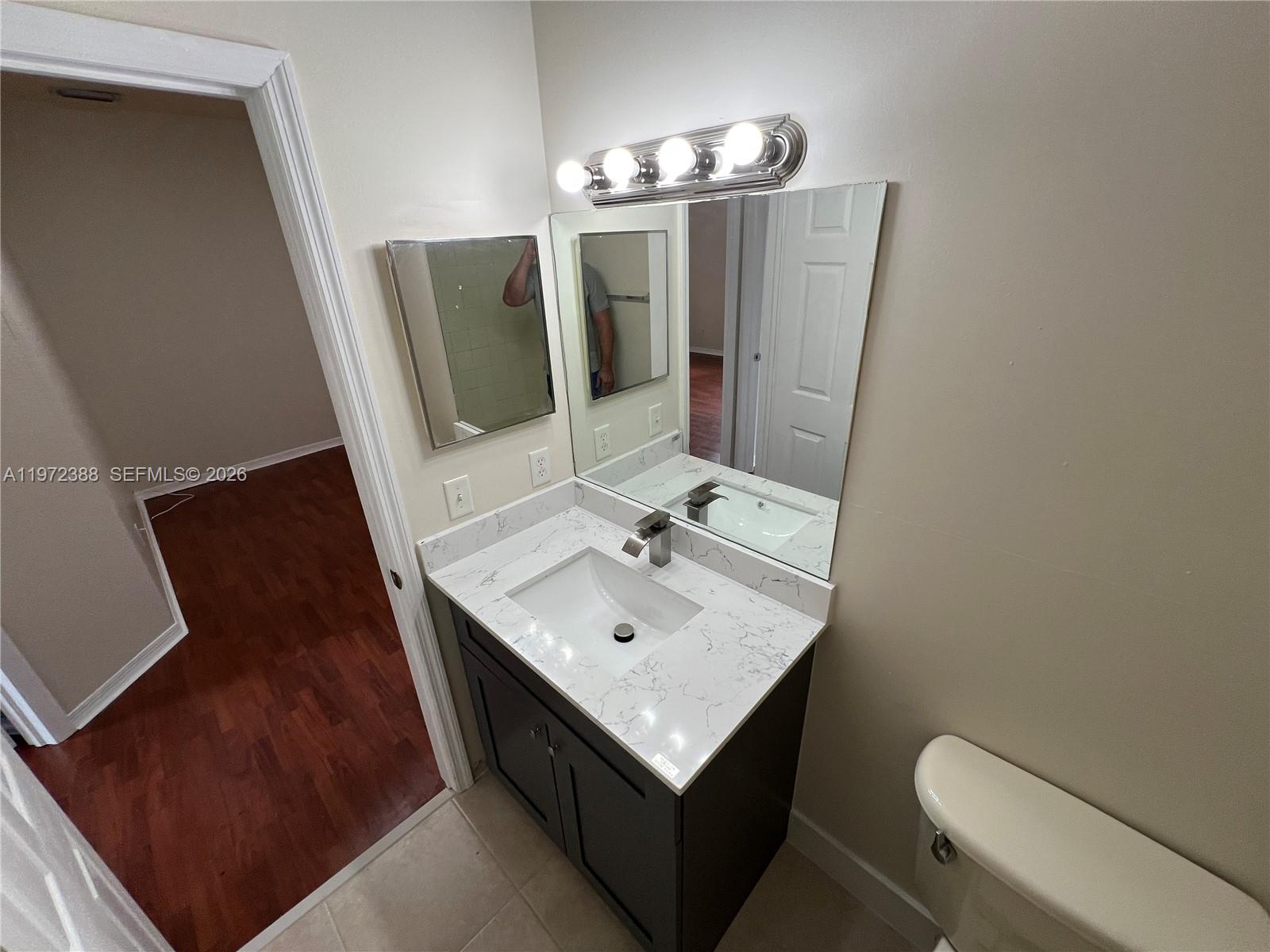 100 Southwest 15th Avenue Homestead, FL 33030 - Photo 52 of 62 a bathroom with a sink a mirror and toilet