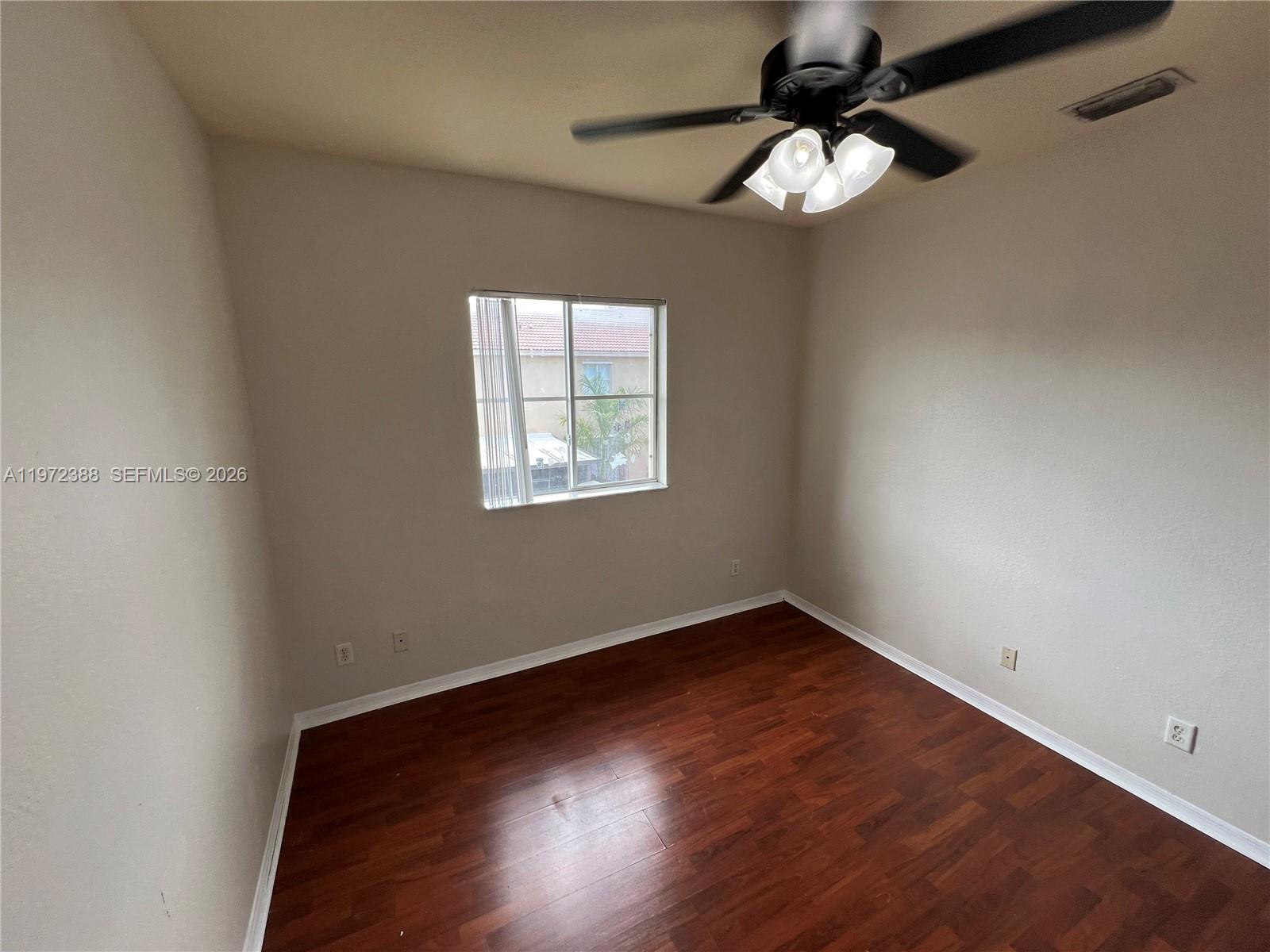 100 Southwest 15th Avenue Homestead, FL 33030 - Photo 55 of 62 a view of an empty room with wooden floor and a window