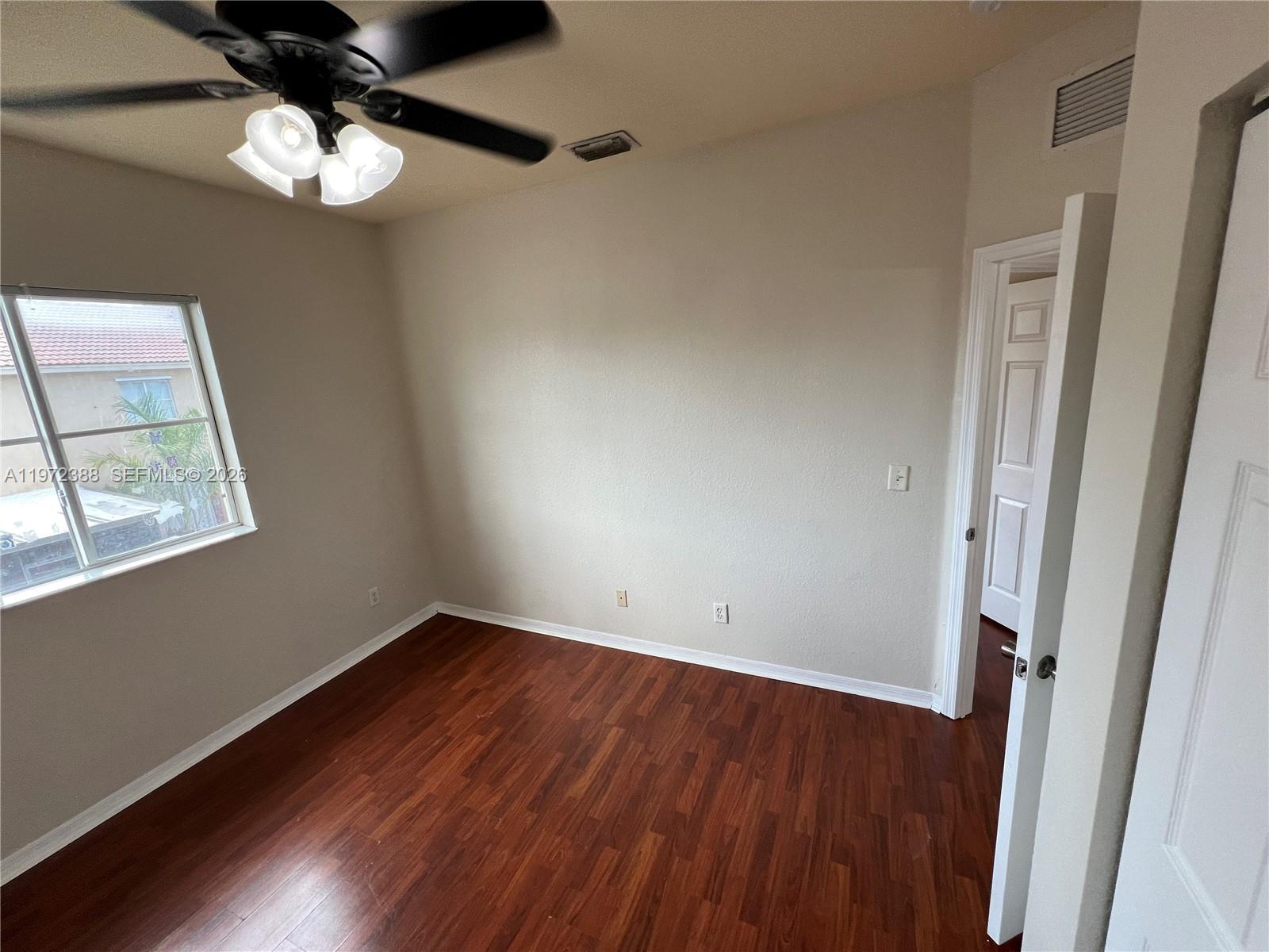 100 Southwest 15th Avenue Homestead, FL 33030 - Photo 56 of 62 a view of an empty room with wooden floor and a window