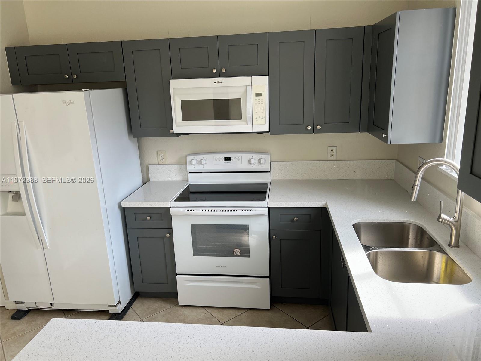 100 Southwest 15th Avenue Homestead, FL 33030 - Photo 10 of 62 a kitchen with a refrigerator sink and cabinets