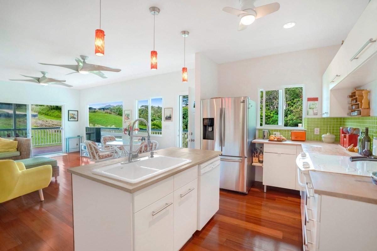 6431 Poo Road, Unit 2 Kapaa, HI 96746 - Photo 6 of 30 a kitchen with kitchen island white cabinets and stainless steel appliances
