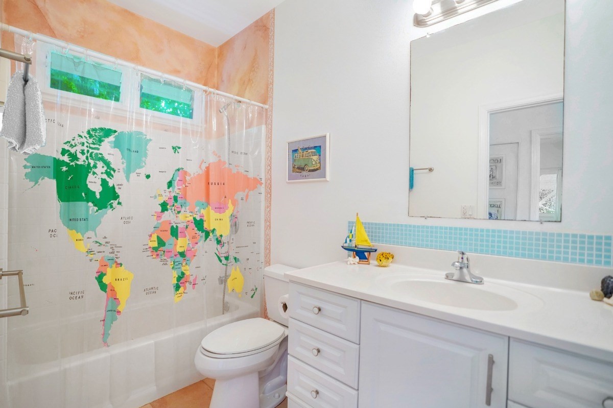 6431 Poo Road, Unit 2 Kapaa, HI 96746 - Photo 9 of 30 a bathroom with a sink a toilet and a shower curtain