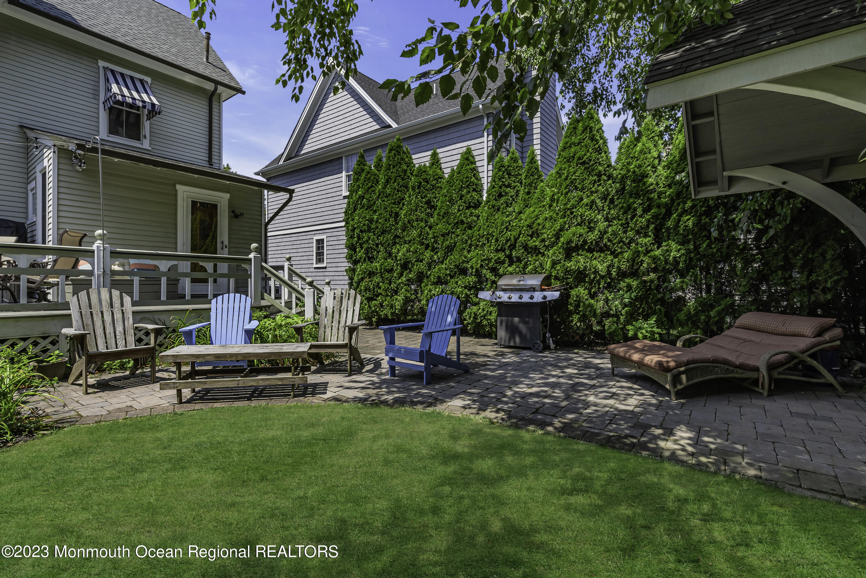 424 Mercer Avenue Spring Lake, NJ 07762 - Photo 34 of 36 a view of a backyard with table and chairs potted plants and a large tree