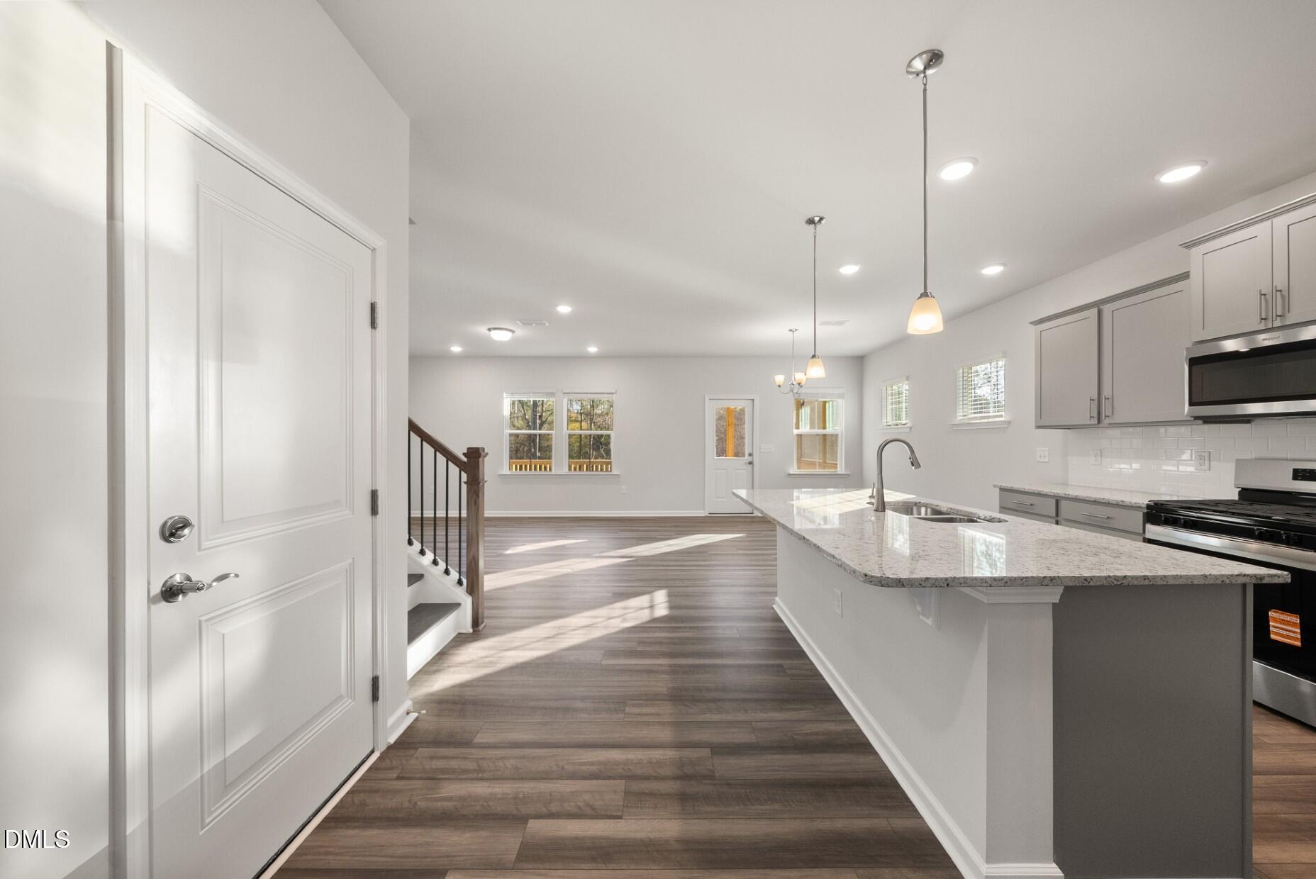 232 Bridle Brk Way Fuquay-Varina, NC 27526 - Photo 4 of 28 a large kitchen with kitchen island a stove a sink a refrigerator and a wooden floor
