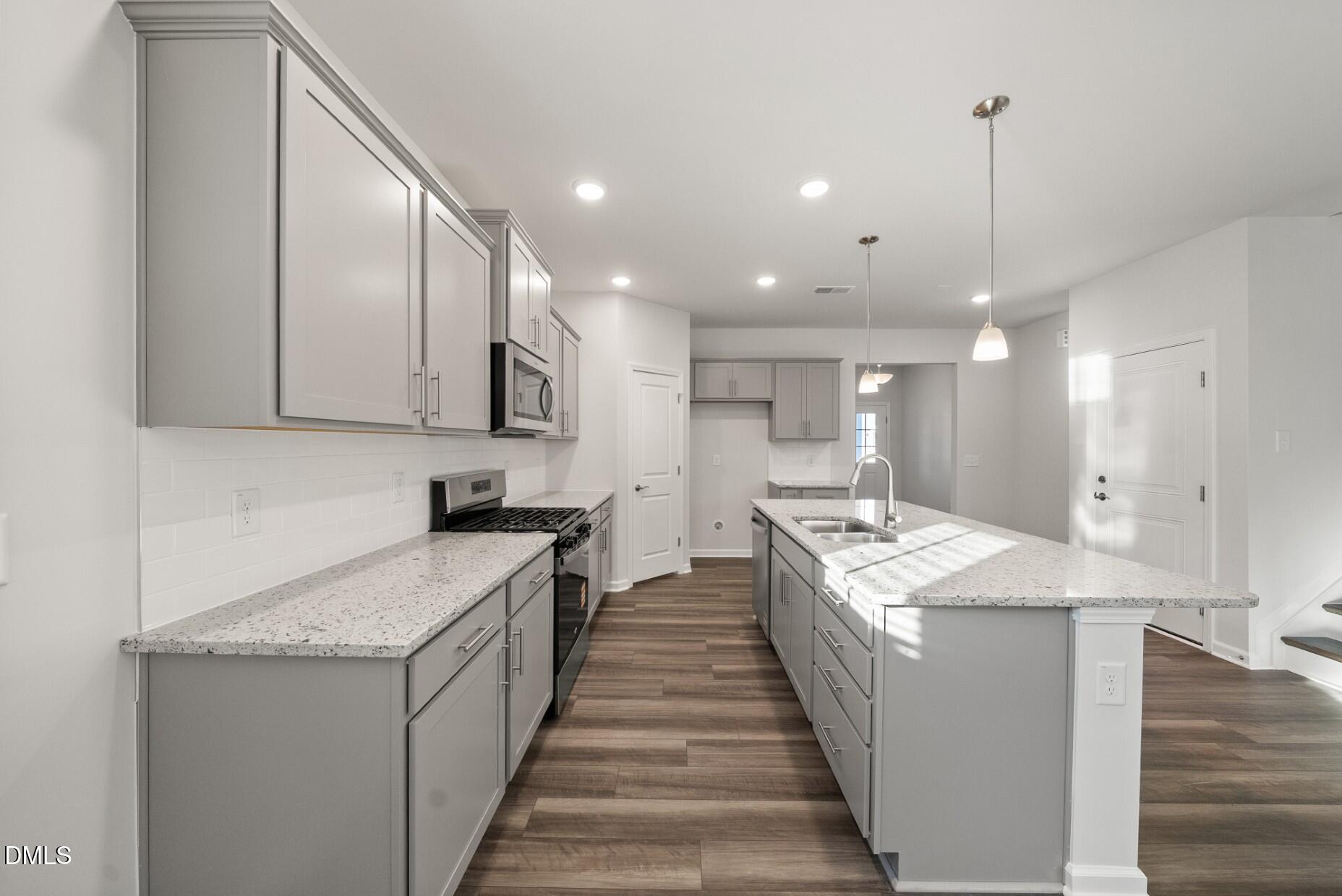 232 Bridle Brk Way Fuquay-Varina, NC 27526 - Photo 5 of 28 a large kitchen with kitchen island a sink a counter top space and stainless steel appliances
