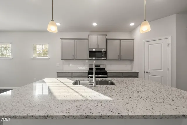 a large kitchen with kitchen island a sink a counter top space and stainless steel appliances