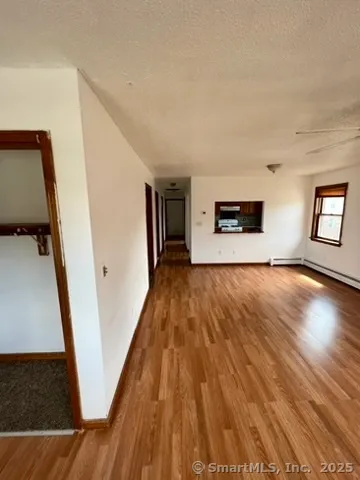 a view of a hallway with wooden floor and staircase