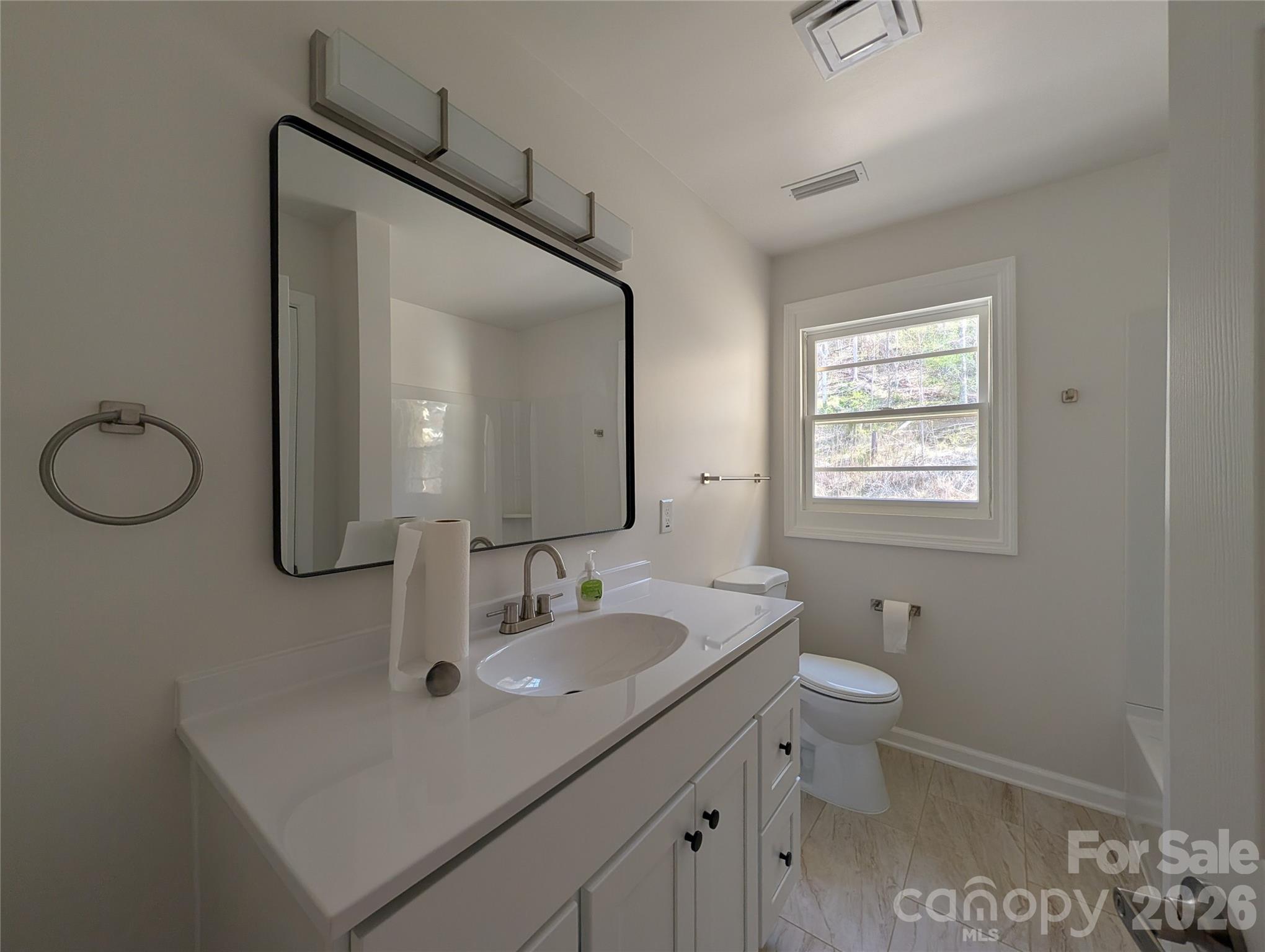945 Summers Road Valdese, NC 28690 - Photo 13 of 25 a bathroom with a toilet sink and mirror