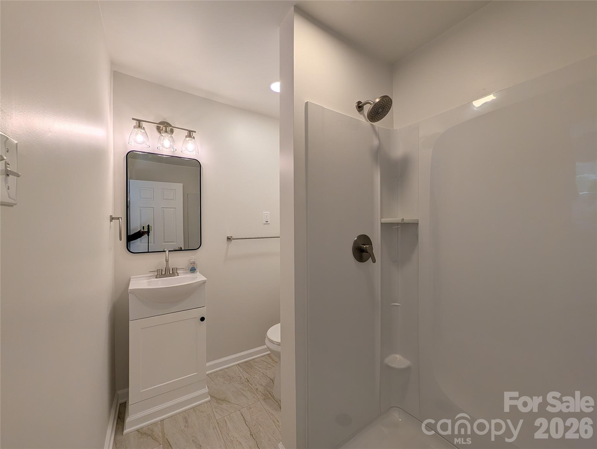 945 Summers Road Valdese, NC 28690 - Photo 16 of 25 a bathroom with a sink a mirror a vanity and shower