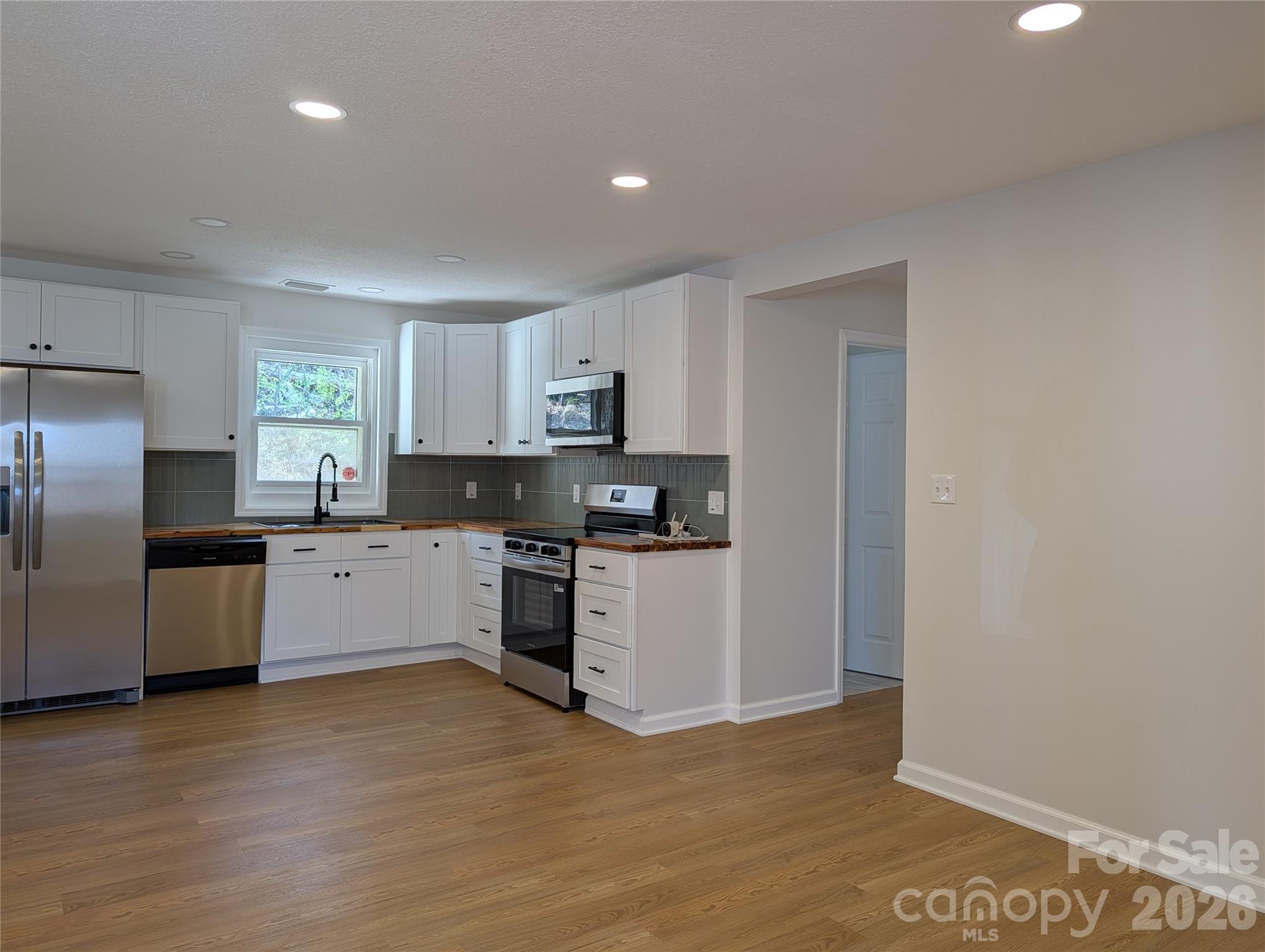 945 Summers Road Valdese, NC 28690 - Photo 2 of 25 a kitchen with granite countertop a refrigerator and a stove top oven