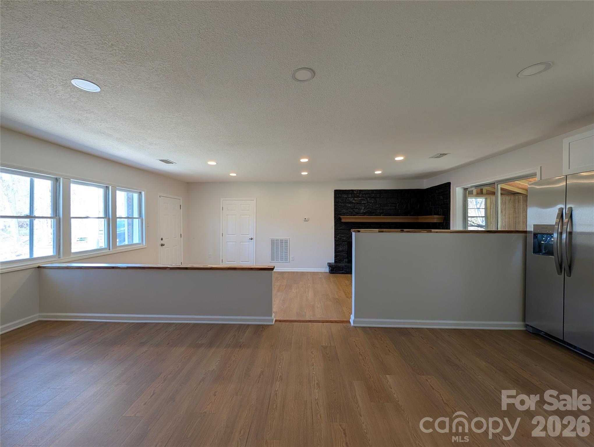 945 Summers Road Valdese, NC 28690 - Photo 6 of 25 an empty room with wooden floor and windows