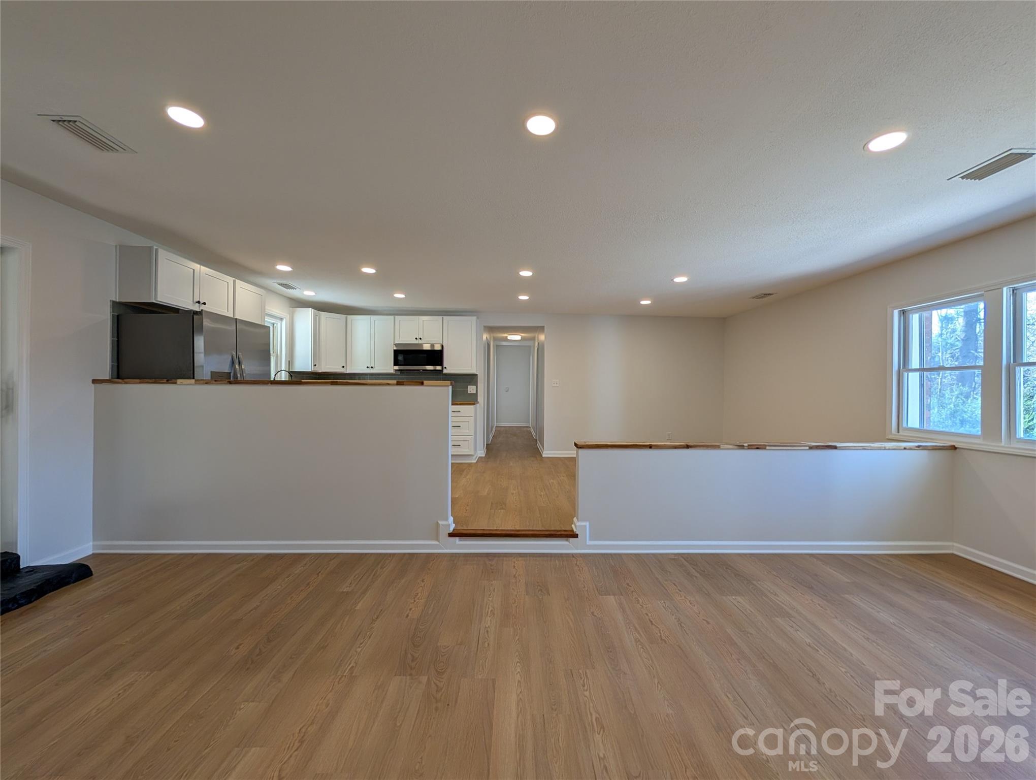 945 Summers Road Valdese, NC 28690 - Photo 6 of 25 an empty room with wooden floor and windows