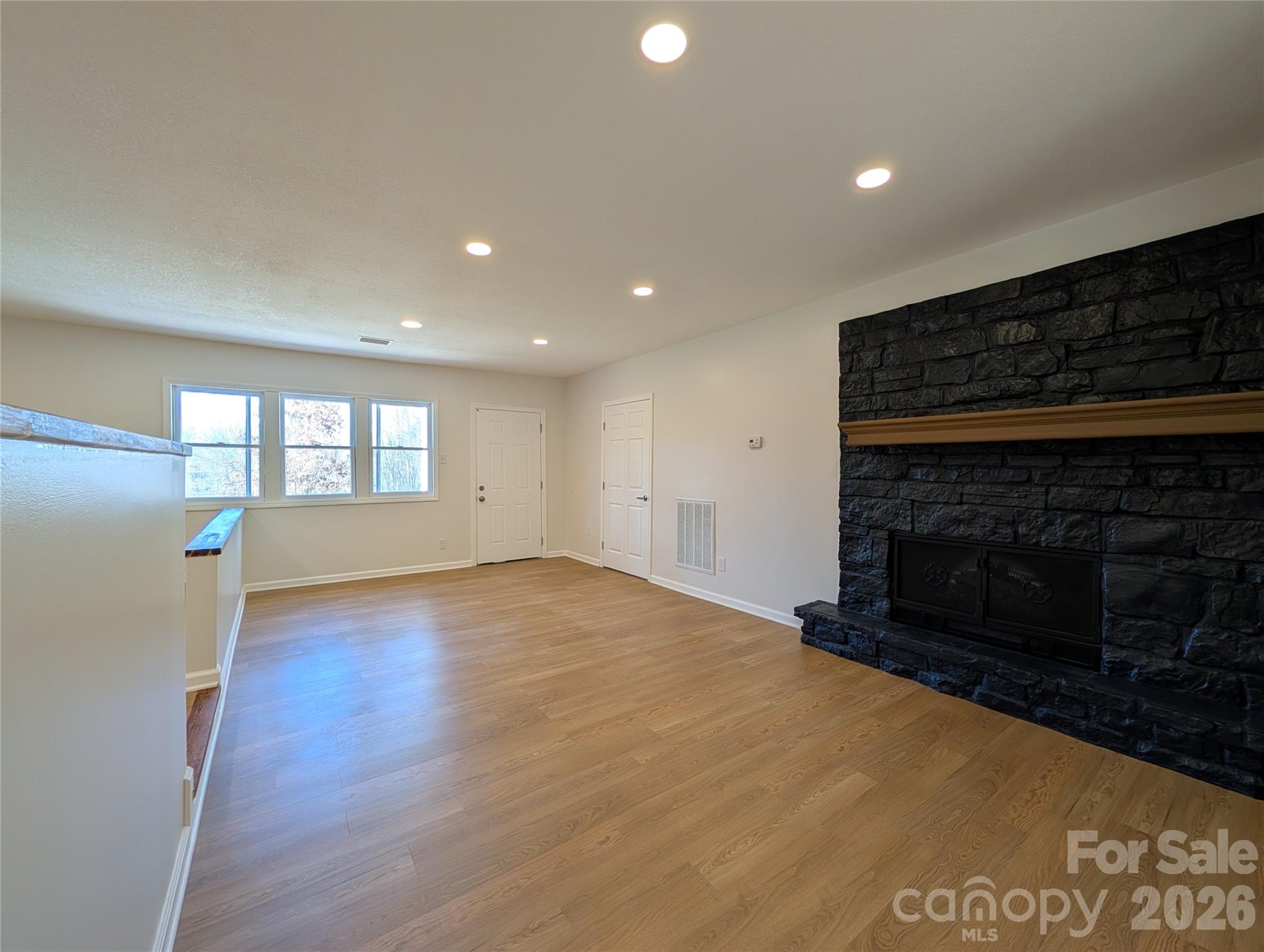 945 Summers Road Valdese, NC 28690 - Photo 7 of 25 a view of empty room with wooden floor and fireplace