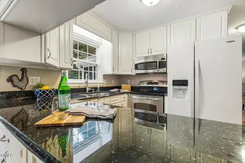 a kitchen with stainless steel appliances granite countertop a stove refrigerator and a microwave