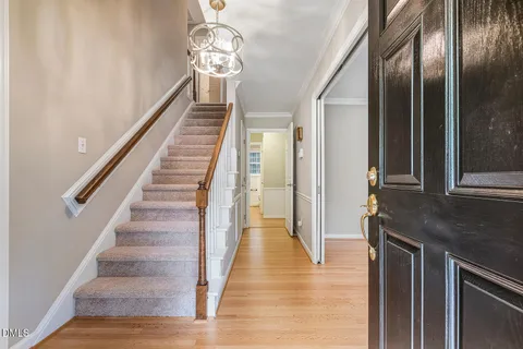 a view of a hallway with wooden floor and staircase