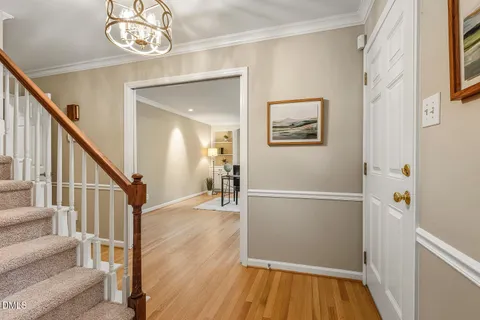 a view of a hallway with wooden floor and staircase