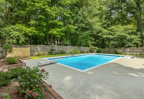a view of a swimming pool with a yard and trees