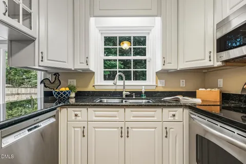 a kitchen with granite countertop a sink and cabinets