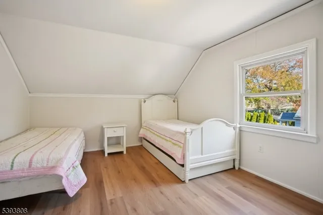 a white bed sitting in a bedroom next to a window