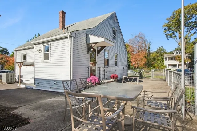 a view of a house with backyard and a tree