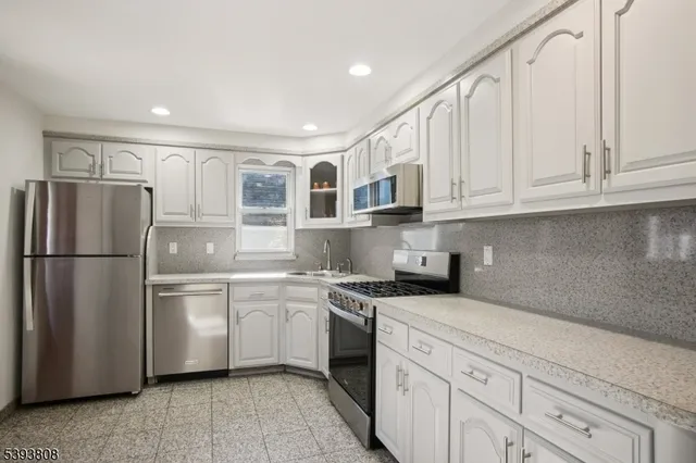 a kitchen with stainless steel appliances granite countertop a refrigerator sink and cabinets