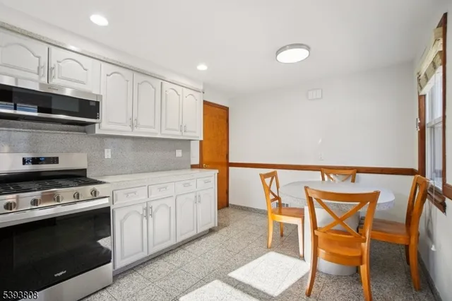 a kitchen with stainless steel appliances a stove a sink cabinets and a dining table