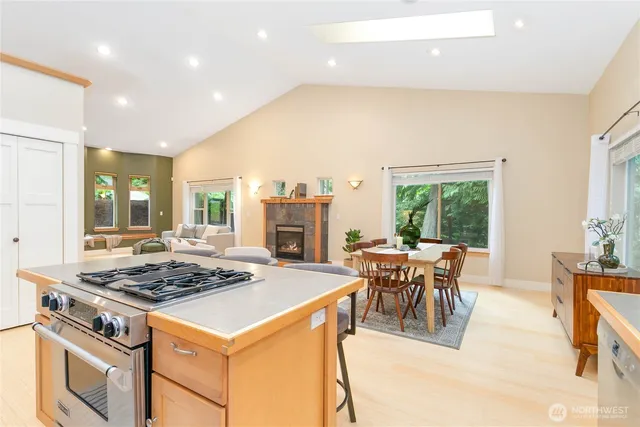 a kitchen with a stove a kitchen island a table and chairs in it