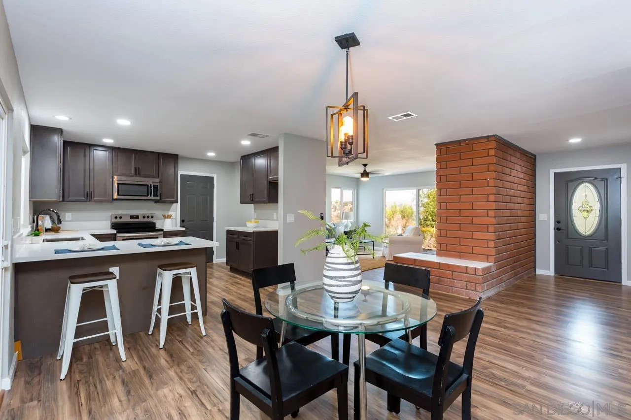 a kitchen with a dining table chairs stainless steel appliances and cabinets