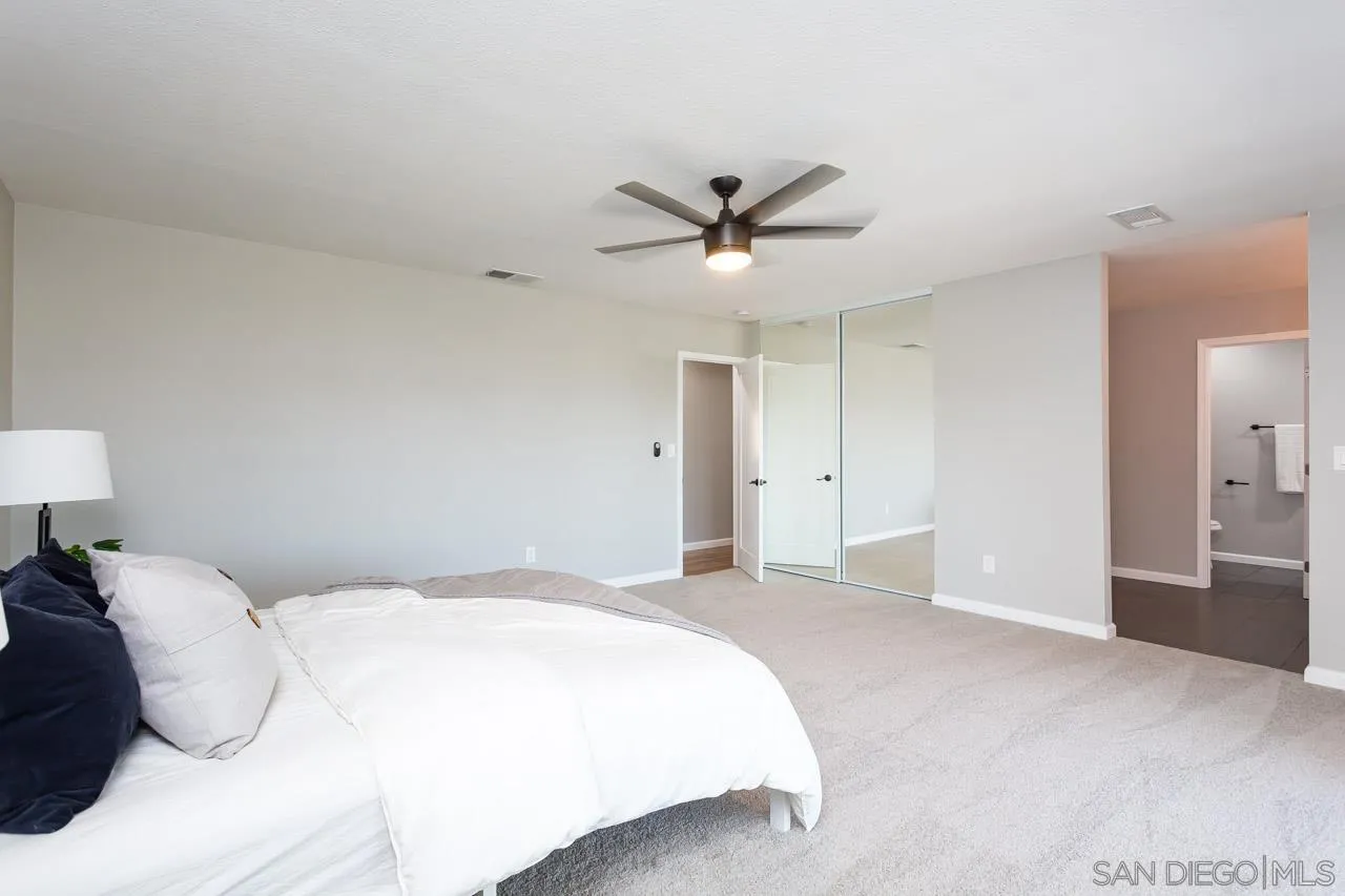 11834 Rocoso Road Lakeside, CA 92040 - Photo 20 of 28 a spacious bedroom with a large bed and a chandelier