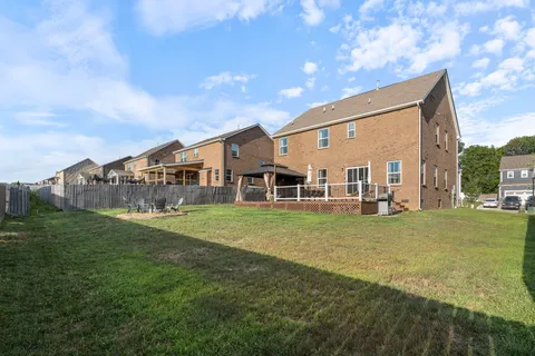 a view of a big house with a big yard and large trees