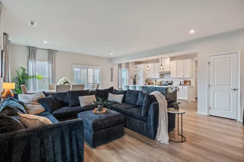 a living room with furniture and a wooden floor
