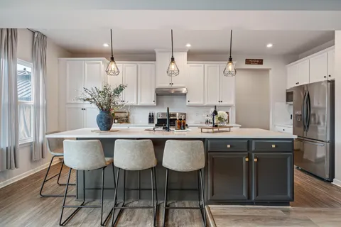 a kitchen with stainless steel appliances granite countertop a sink a stove a refrigerator and island with wooden floor