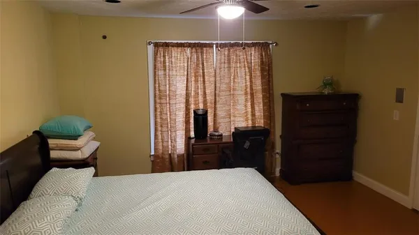 a bedroom with a bed and wooden floor