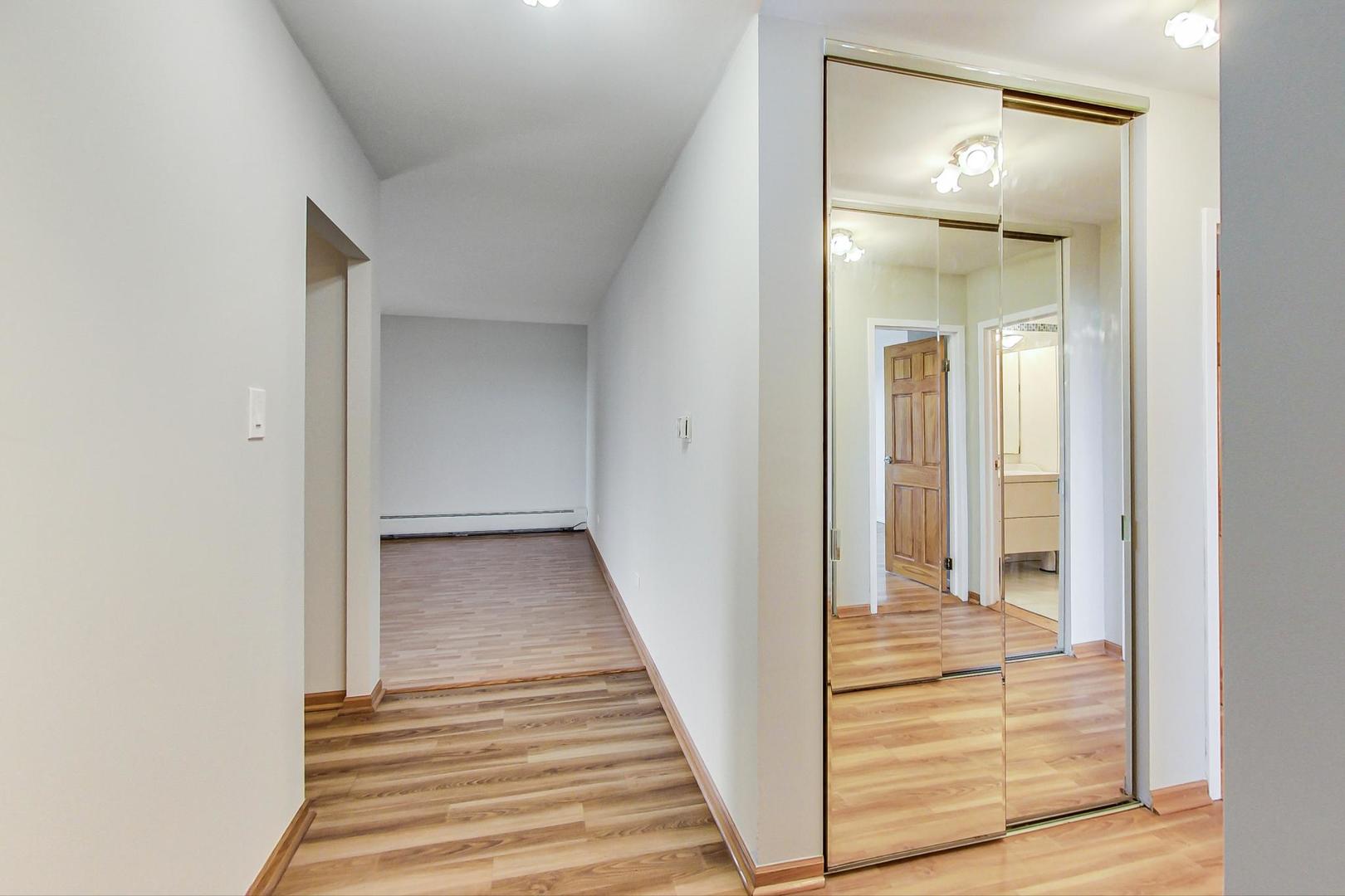 9009 Golf Road, Unit 8B Des Plaines, IL 60016 - Photo 12 of 42 a view of a hallway with wooden floor and staircase