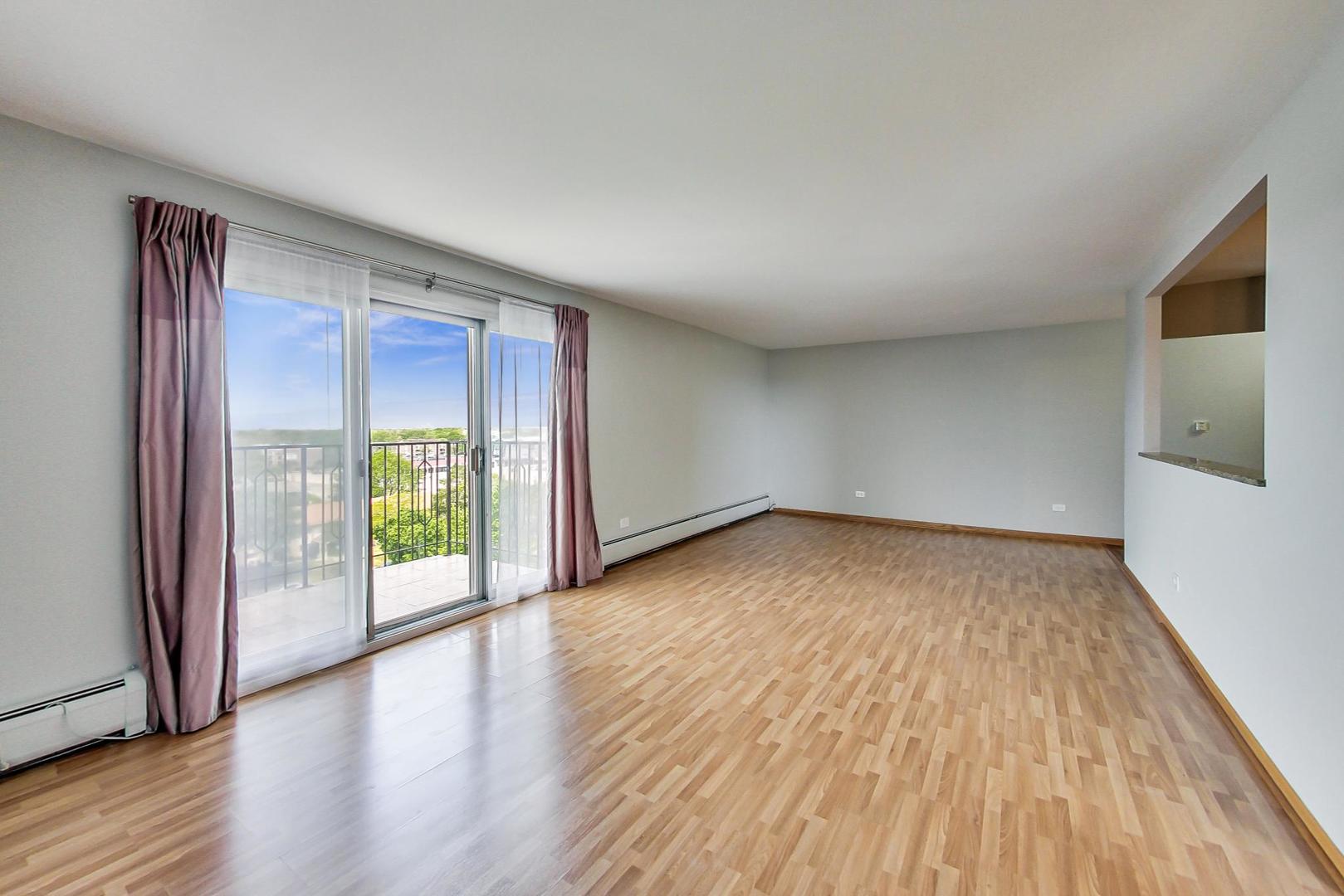 9009 Golf Road, Unit 8B Des Plaines, IL 60016 - Photo 16 of 42 a view of an empty room with wooden floor and a window