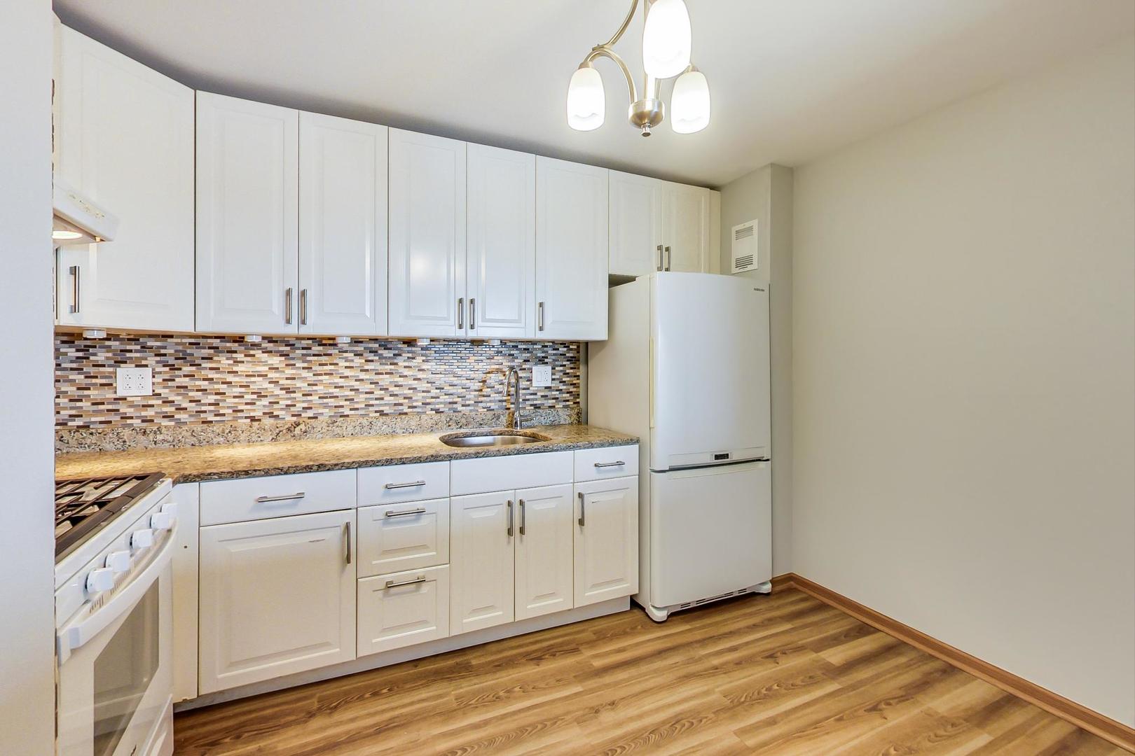 9009 Golf Road, Unit 8B Des Plaines, IL 60016 - Photo 17 of 42 a kitchen with granite countertop white cabinets and white appliances