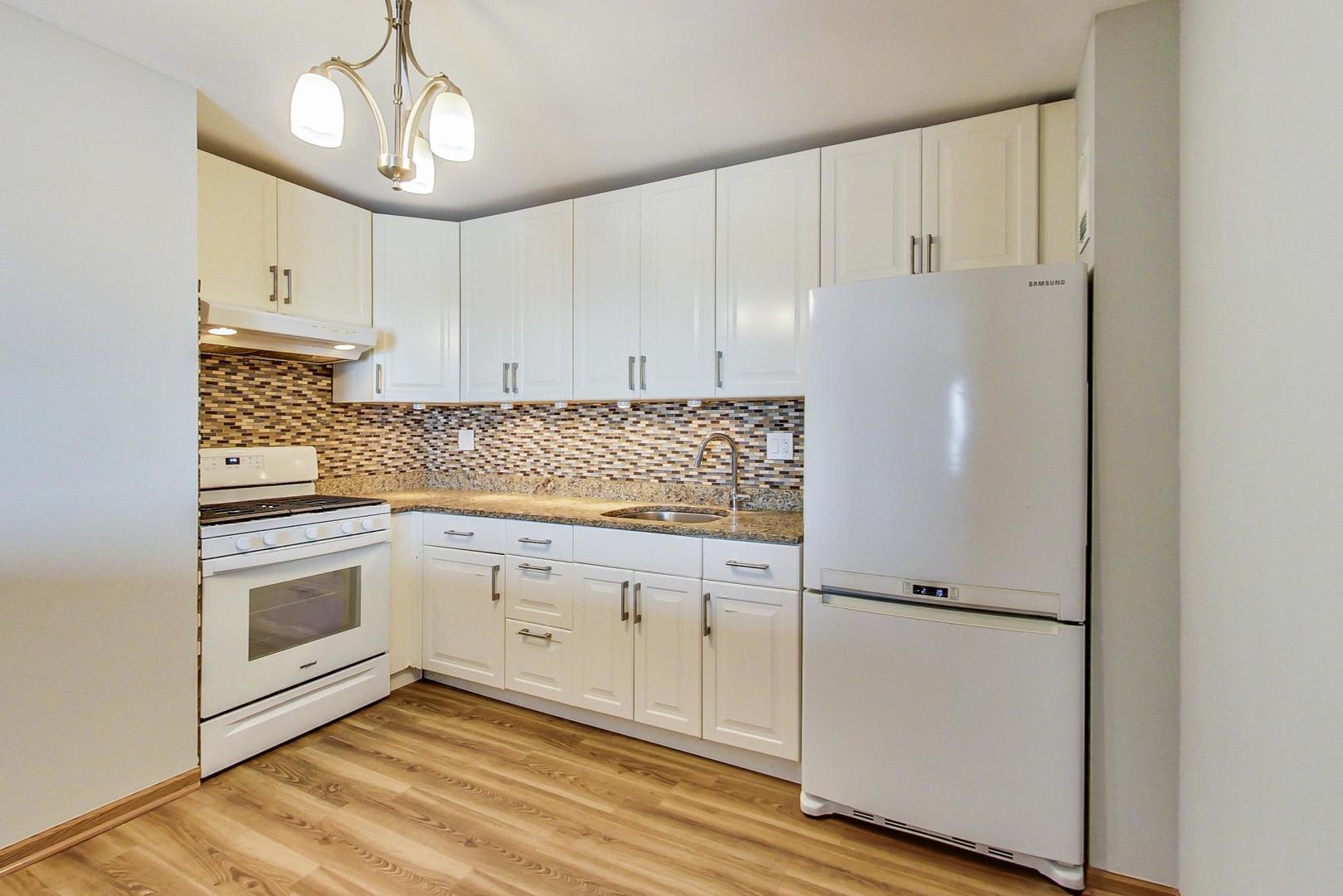 9009 Golf Road, Unit 8B Des Plaines, IL 60016 - Photo 18 of 42 a kitchen with granite countertop white cabinets and white appliances
