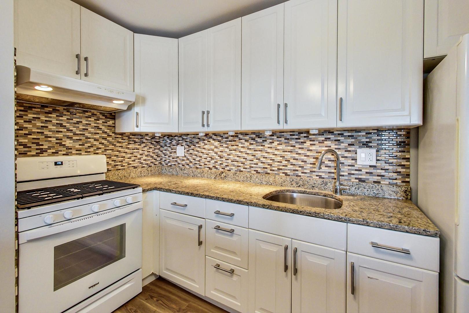 9009 Golf Road, Unit 8B Des Plaines, IL 60016 - Photo 19 of 42 a kitchen with granite countertop white cabinets and white appliances