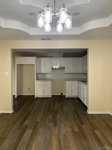 a view of a room with wooden floor and cabinets