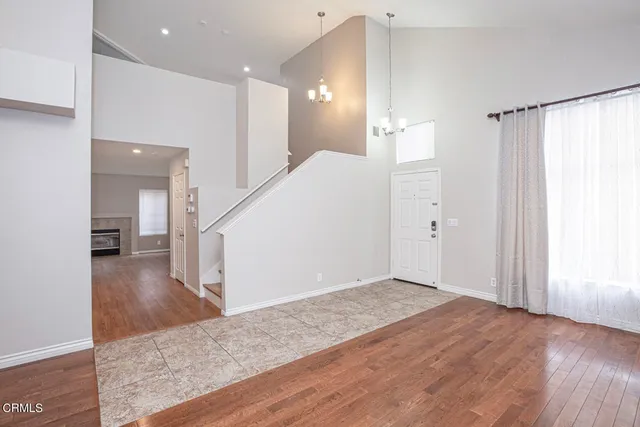 a view of a hallway with wooden floor and a bathroom